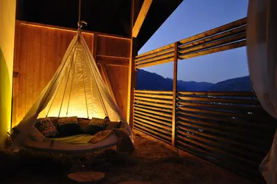 a hammock in a tent with a view of the mountains at Ferienwohnungen Niederhof in Lana