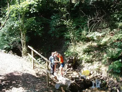 two people standing on a trail near a stream at Ferienwohnungen Niederhof in Lana