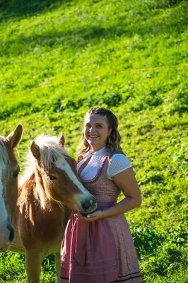 a girl is standing next to a horse at Schweinsteghof Urlaub auf dem Bauernhof in Sarntal