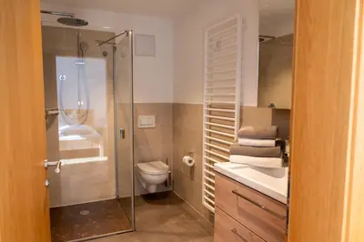 a bathroom with a toilet and a glass shower at Schweinsteghof Urlaub auf dem Bauernhof in Sarntal