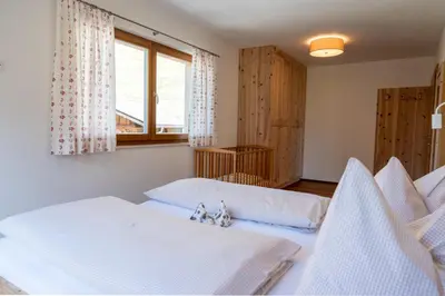 a bedroom with two beds and a window at Schweinsteghof Urlaub auf dem Bauernhof in Sarntal