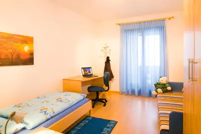 a bedroom with a bed and a desk and a chair at Appartements Peilerhof in Cermes