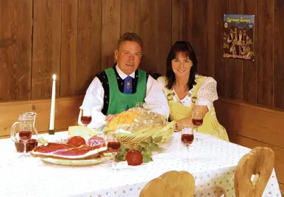 a man and woman sitting at a table with wine glasses at Appartements Peilerhof in Cermes