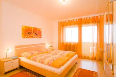 a bedroom with a bed and a large window at Appartements Peilerhof in Cermes