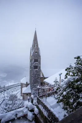 a church with a tower covered in snow at Frühaufhof in Barbiano