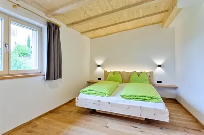 a bedroom with a bed with green pillows at Frühaufhof in Barbiano