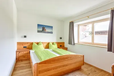 a bedroom with a wooden bed and a window at Frühaufhof in Barbiano