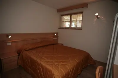 a bedroom with a bed and a window at Villetta ai Pini Deluxe in Canazei