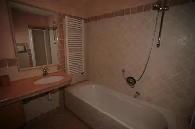 a bathroom with a bath tub and a sink at Villetta ai Pini Deluxe in Canazei