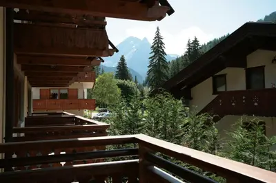 a balcony of a building with a view of the mountains at Villetta ai Pini Deluxe in Canazei