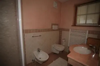 a bathroom with a toilet and a bidet and a sink at Villetta ai Pini Deluxe in Canazei
