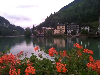a view of a river with buildings and flowers at Europa Mountain Apartments in Alleghe