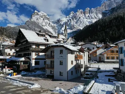 a village in the mountains with snow on the roofs at Europa Mountain Apartments in Alleghe