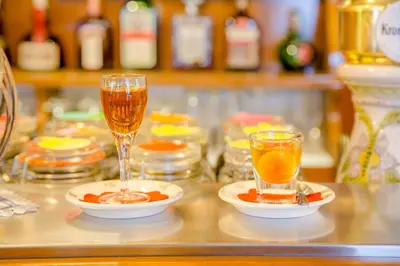 two glasses of champagne and plates of food on a counter at Albergo Genzianella in Rocca Pietore