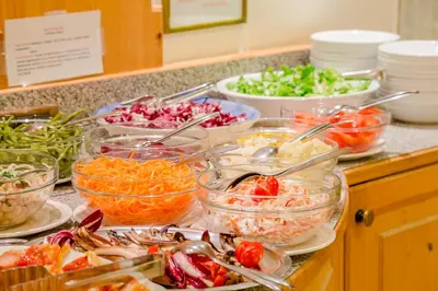 a buffet with bowls of different types of vegetables at Albergo Genzianella in Rocca Pietore