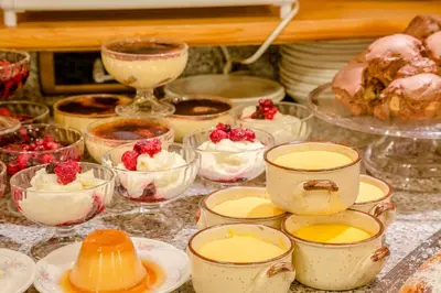 a table topped with pies and desserts in dishes at Albergo Genzianella in Rocca Pietore