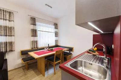 a small kitchen with a small table and a sink at Appartement Riederhof in Saltusio