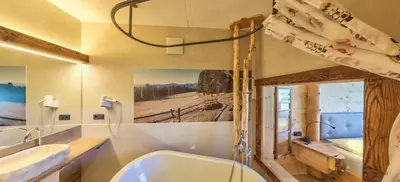 a bathroom with a bath tub and a sink at Albergo Gasthof zur Krone in Laion