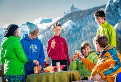a group of people standing around a table with drinks at Hotel Piccolo Pocol in Cortina dʼAmpezzo