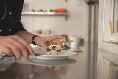 a person holding a plate of food on a counter at Hotel La Soldanella in Moena