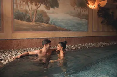 two people in a swimming pool in a building at Hotel La Soldanella in Moena