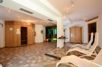 a living room with white chairs and a table at Hotel La Soldanella in Moena