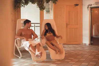 a man and a woman sitting on beach chairs at Hotel La Soldanella in Moena