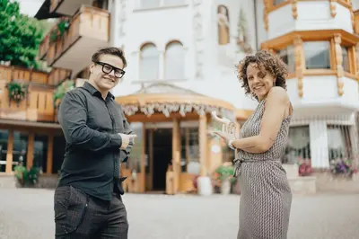 a man and a woman standing in front of a building at Hotel La Soldanella in Moena
