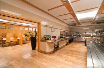 a large kitchen and dining room with tables and chairs at Kolpinghaus Bolzano in Bolzano