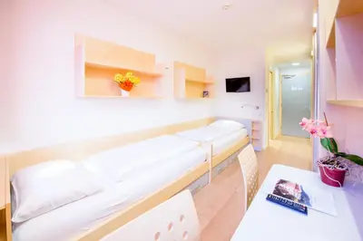 a hospital room with a bed and a table at Kolpinghaus Bolzano in Bolzano