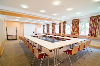 a conference room with a long table and chairs at Kolpinghaus Bolzano in Bolzano