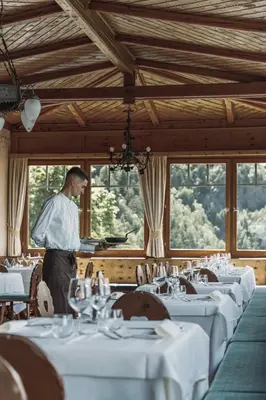 a man standing in a dining room with tables at Gasthof Kohlern 1130 m in Bolzano