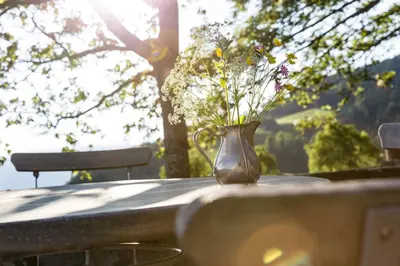 a vase filled with flowers sitting on top of a table at Gasthof Kohlern 1130 m in Bolzano
