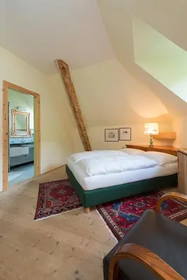 a bedroom with a bed and a rug at Gasthof Kohlern 1130 m in Bolzano