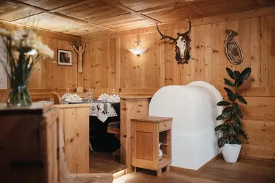 a room with wooden walls and a kitchen with a table at Garni Ciasa Urban in Badia