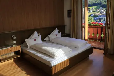 a bed with pillows on it in a room at Garni Panoramik in Ortisei