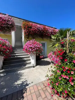 a house with pink flowers on the side of it at Gartenhof in Bressanone