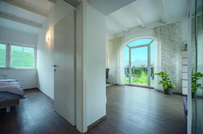 an empty room with a bed and a large window at Gartenhof in Bressanone