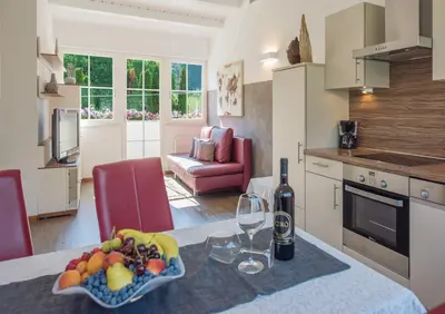 a kitchen with a table with a bowl of fruit and wine glasses at Gartenhof in Bressanone