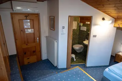 a small bathroom with a toilet and a door at Garni Meinrad in Ora/Auer