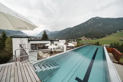 a swimming pool with a view of a mountain at Al Plan, A mountain moving hotel in San Vigilio Di Marebbe