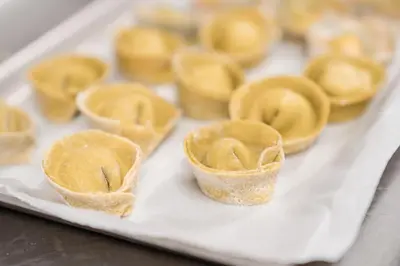 a tray filled with yellow pastries on a table at Al Plan, A mountain moving hotel in San Vigilio Di Marebbe