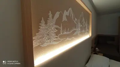 a picture of trees on the wall of a hotel room at Residence Montebel in Tesero