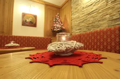 a table with a red napkin on a table with a candle at Residence Montebel in Tesero