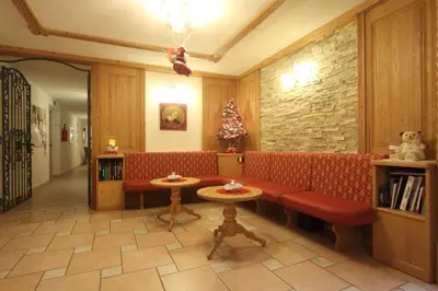 a living room with a red couch and a christmas tree at Residence Montebel in Tesero