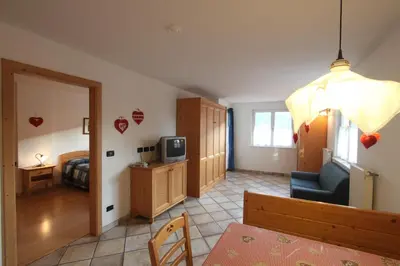 a room with a bedroom and a living room at Residence Montebel in Tesero