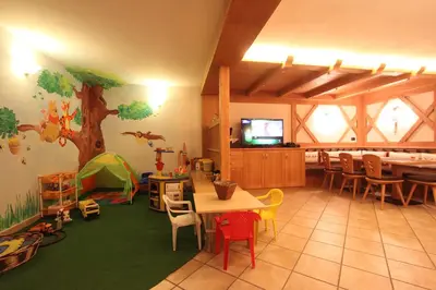 a room with a table and chairs and a tv at Residence Montebel in Tesero