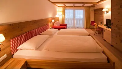 a bedroom with two beds in a room at Hotel Foestlerhof in Villa Ottone