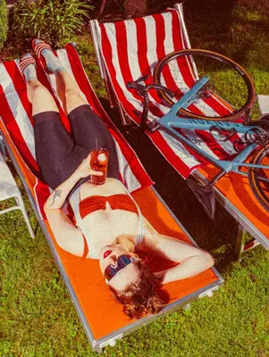 a woman laying on a beach chair on the grass at Amadeus Ora & Amore in Caldaro