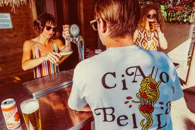 a man standing at a bar with a woman drinking beer at Amadeus Ora & Amore in Caldaro